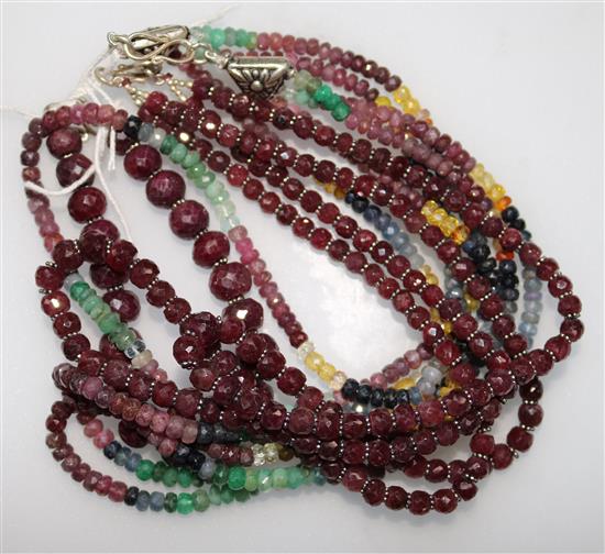 An Indian double strand facetted ruby bead necklace, a similar bracelet and a multi gem set triple strand necklace.